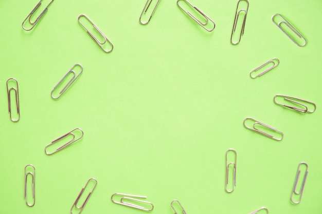 Free photo high angle view of paper clips on green background