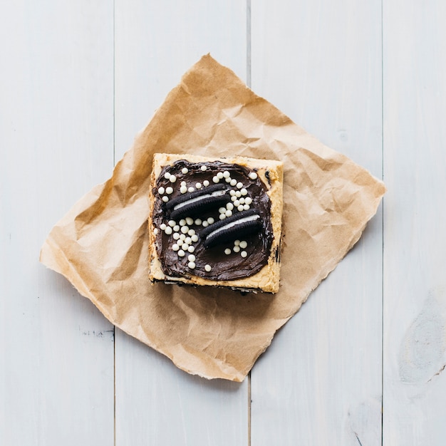 Free photo high angle view of pastry decorated with cookies on wooden plank