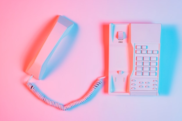 High angle view of pink retro landline telephone with receiver