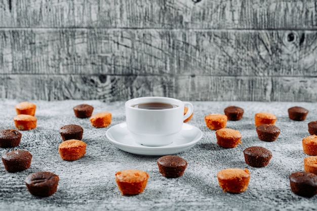 Free Photo high angle view small cakes with tea on light textured