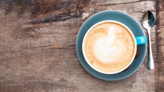 Free photo high angle view of tasty coffee with frothy foam on old wooden backdrop