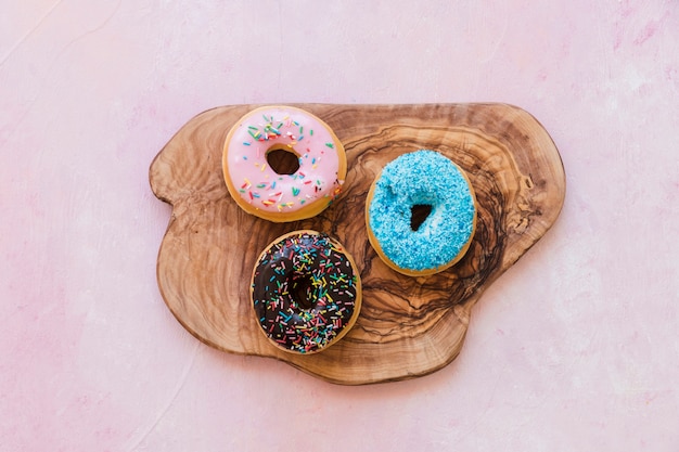 Free photo high angle view of tasty donuts on wooden chopping board