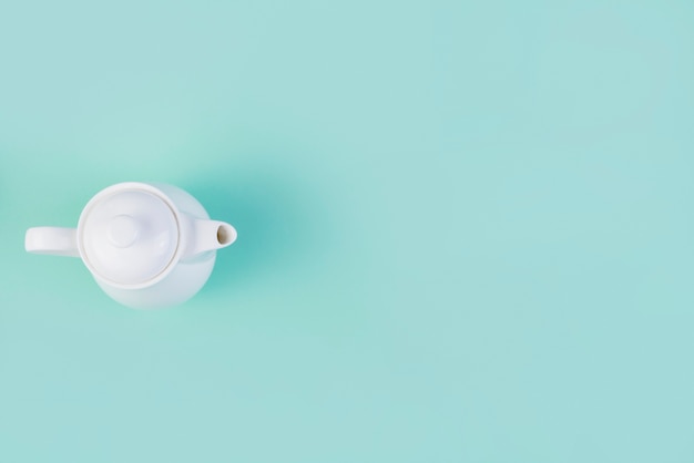 Free photo high angle view of tea kettle on green background