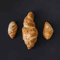 Free photo high angle view of three fresh croissants on black background