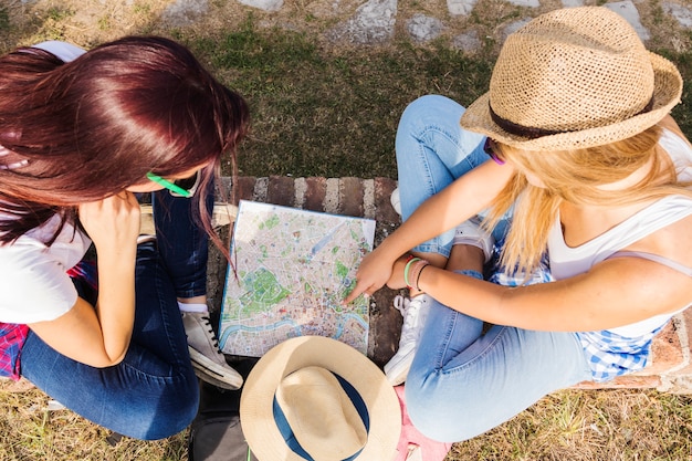 High angle view of two female hikers looking for direction in map