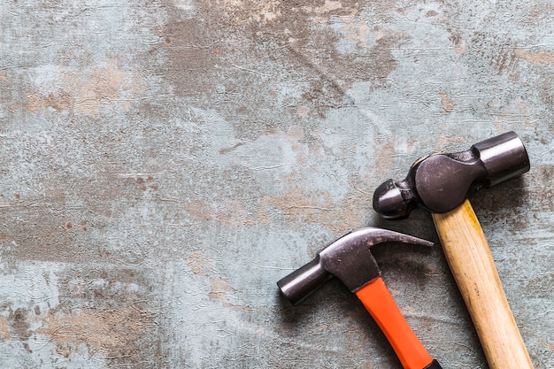 High angle view of two hammers on old wooden desk