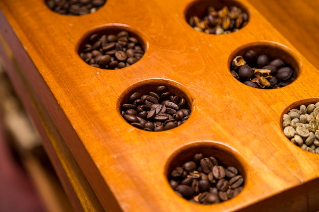 Free Photo high angle view of various coffee beans in wooden container