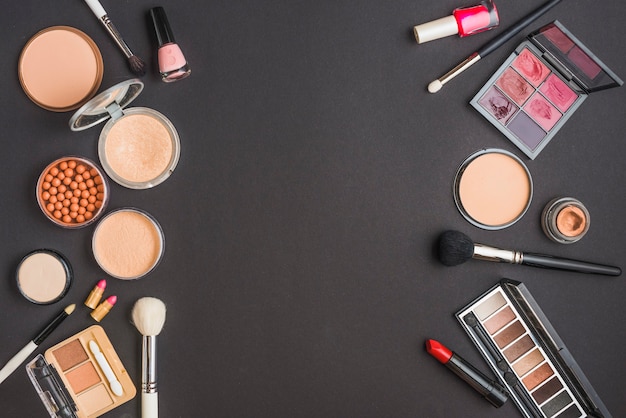 High angle view of various makeup products on black background