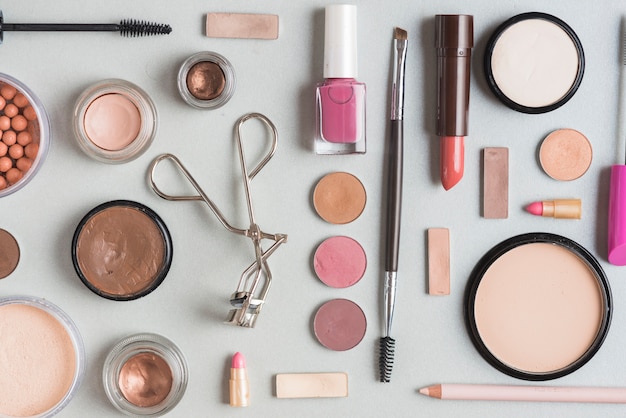 High angle view of various makeup products on white surface