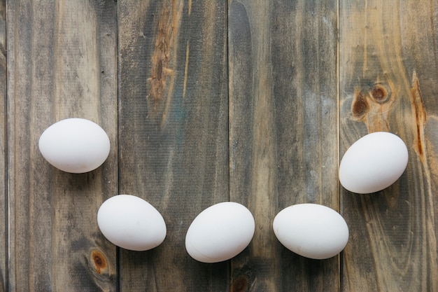 High angle view of white eggs on wooden background