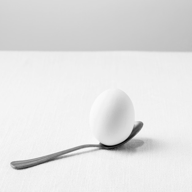 High angle white egg in teaspoon