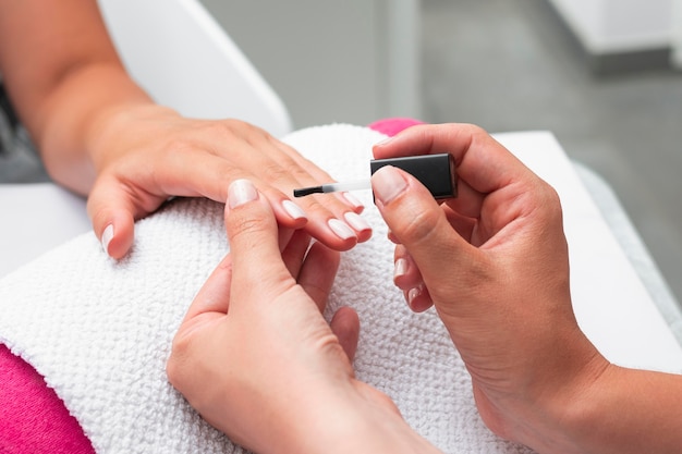 High angle woman doing the manicure of a client