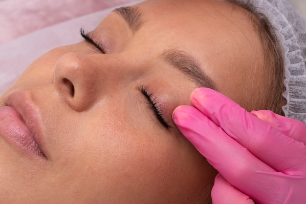 High angle woman at eyelashes extension application