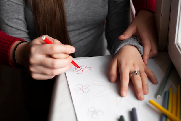 Free photo high angle of woman and girl with down syndrome drawing