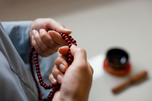 High angle of woman holding beads and meditating