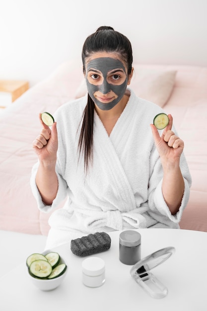 Free photo high angle woman holding cucumber slices