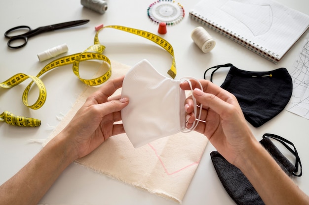 High angle of woman holding face mask she sew