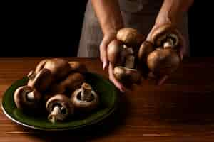 Free photo high angle woman holding mushrooms