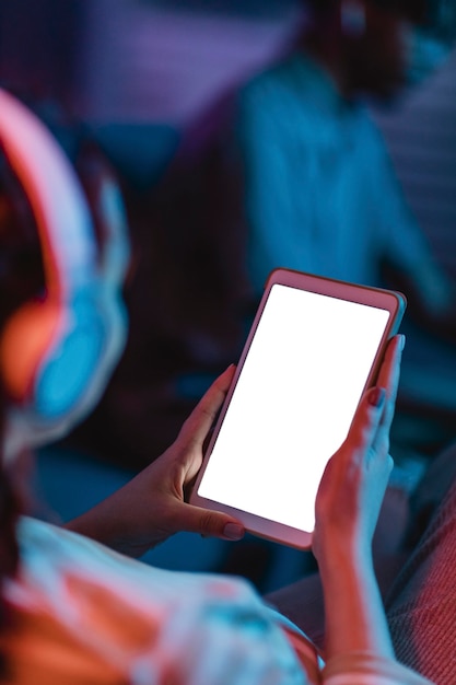 High angle of woman at home using headphones and tablet