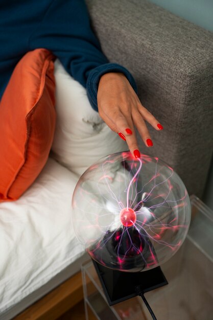 High angle woman interacting with a plasma ball