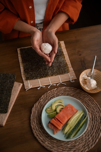 Free Photo high angle woman learning to make sushi