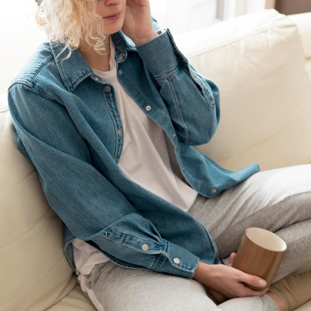 High angle woman listening to music and holding coffee mug