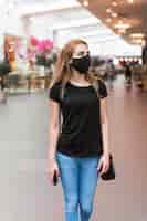 Free photo high angle woman at mall wearing mask