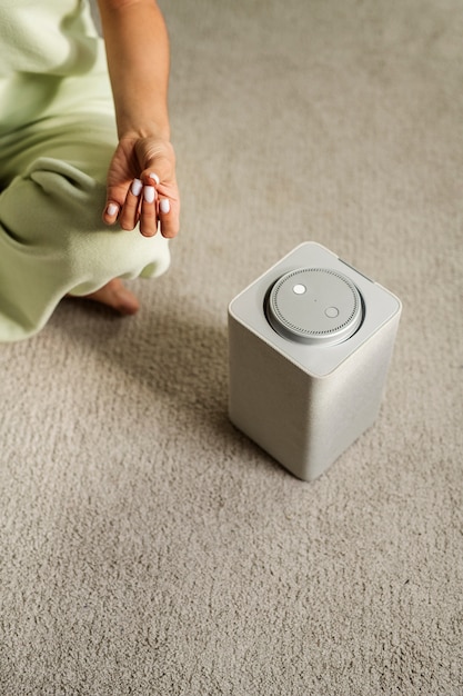 Free Photo high angle woman meditating with smart speaker