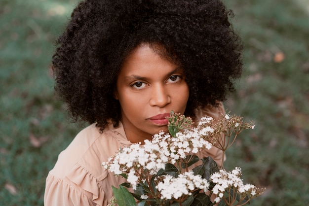 Free photo high angle woman posing with flowers