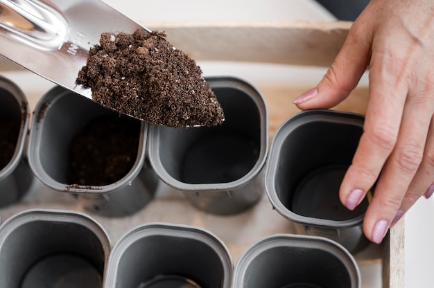 Free photo high angle of woman preparing soil for planting