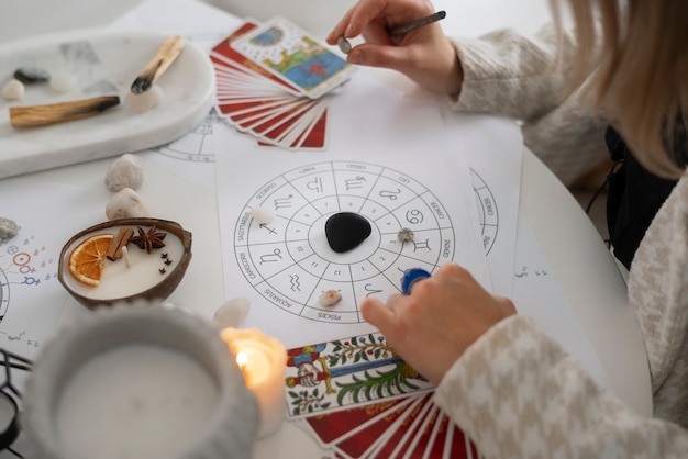 Free photo high angle woman reading tarot at home