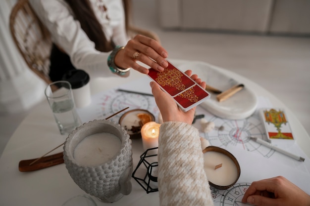 Free photo high angle woman reading tarot at home