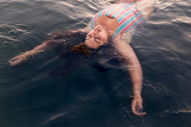 Free photo high angle of woman relaxing in the water at the beach