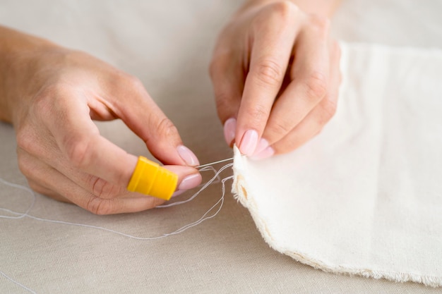 Free photo high angle of woman sewing fabric