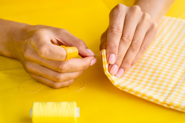 High angle of woman sewing textile