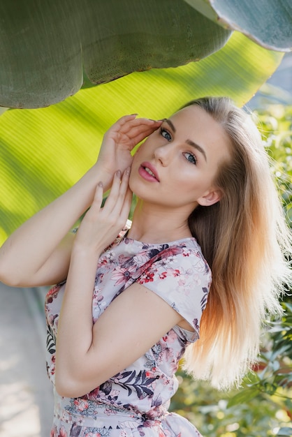 Free photo high angle woman standing under plants leaves