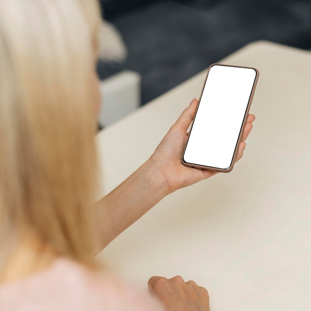 High angle of woman using smartphone at home during the pandemic