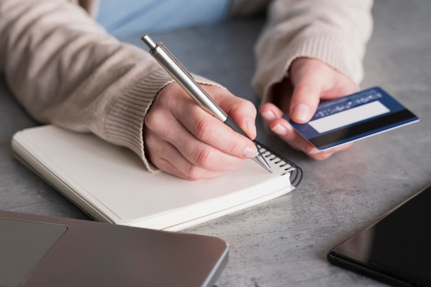 High angle of woman with notebook and credit card