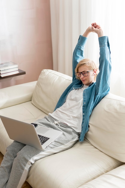 High angle woman working on laptop and stretching