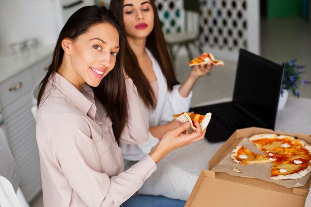 Free photo high angle women looking at camera while eating