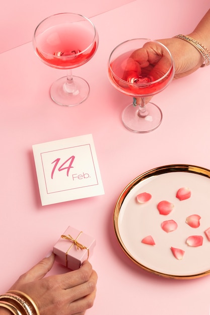 High angle of women's hands with glasses and valentines day gift box