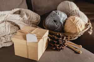 Free photo high angle wooden box with yarn and pine cone