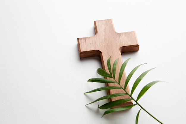 High angle wooden cross and green leaf