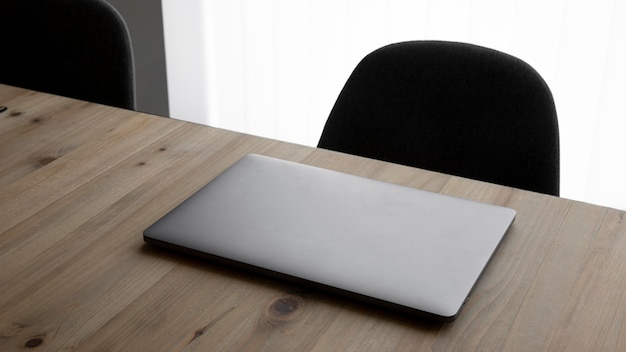 Free photo high angle workplace with laptop and chairs