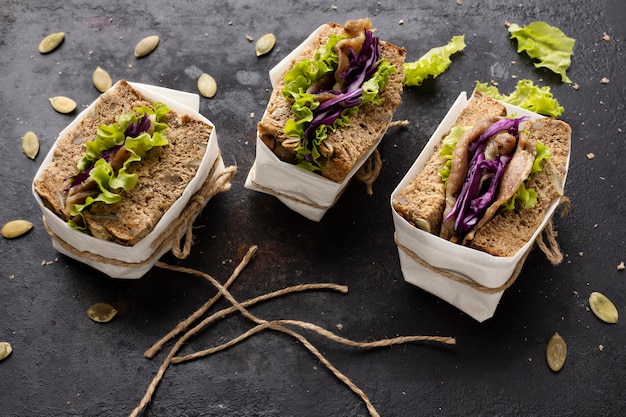 Free Photo high angle of wrapped sandwiches with salad