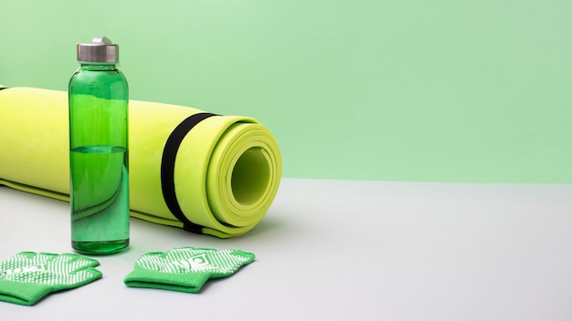 Free photo high angle yoga mat and water bottle