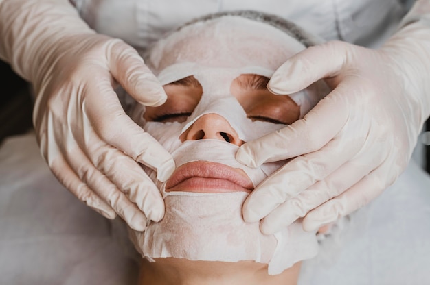 High angle of young beautiful woman getting a skin mask treatment