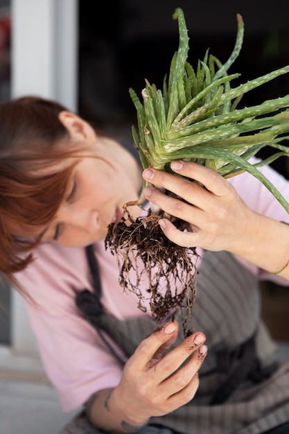 Free photo high angle young woman transplanting plant