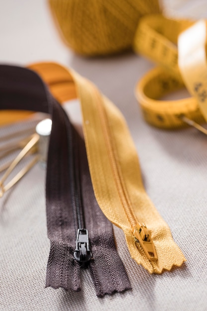 Free Photo high angle of zippers with measuring tape and thread