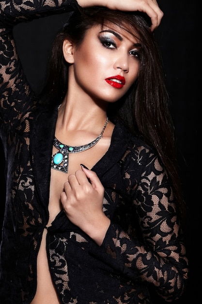 High fashion look.glamor closeup portrait of beautiful sexy stylish brunette Caucasian young woman model with bright makeup, with red lips,  with perfect clean skin with jewelery in black cloth